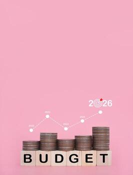 Wooden blocks with the word BUDGET and stack of coins with graph. The concept about budget planning and allocation in year 2026 photo