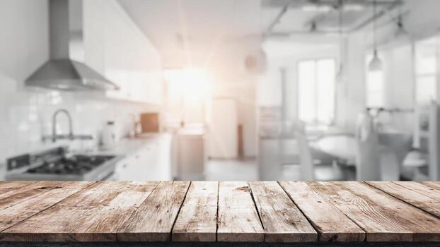 In the foreground is a wooden table with a warm texture. In the blurred background, a kitchen with white furniture is visible, emphasizing the style and comfort of the home environment. photo