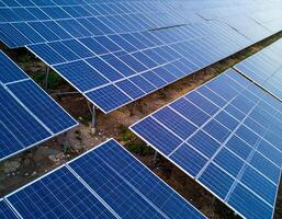 visión de conjunto de solar paneles en contra un verde energía fondo, destacando Respetuoso del medio ambiente electricidad Generacion foto