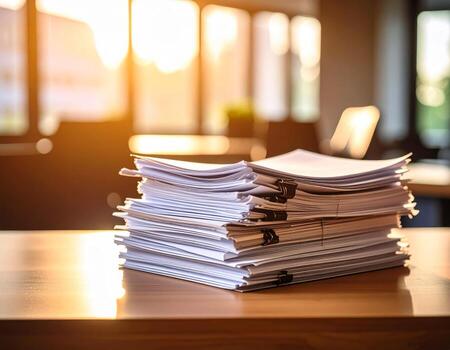 Office desk with a heap of papers and reports stacked up, background filled with more documents photo