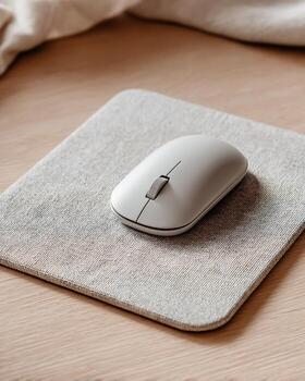 Wireless Computer Mouse on Soft Gray Mouse Pad in Modern Workspace photo