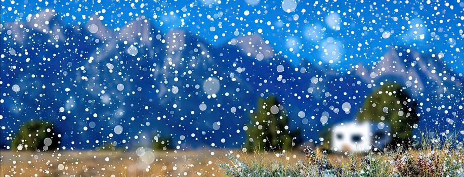 Snow falling on a field with mountains in the background photo