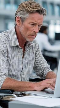 A man in a wheelchair using a laptop computer photo