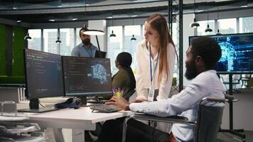 jung Ingenieur und Mitarbeiter mit Querschnittslähmung tun Brainstorming im Büro, Überprüfung ai System Metriken. Junior dev und Kollege im Rollstuhl reden, Tuning neural Netzwerke mit PC, Kamera ein video