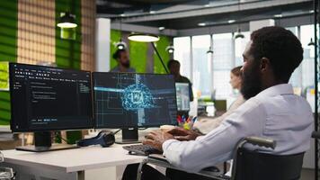 technicus in rolstoel gebruik makend van ai Aan computer naar optimaliseren prestatie en voorspelling problemen. Afrikaanse Amerikaans werknemer met onbekwaamheid in inclusief kantoor opleiding machine aan het leren modellen, camera een video