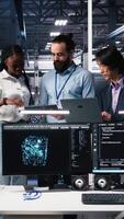 vertikal porträtt av leende ingenjörer i server rum använder sig av ai till recension infrastruktur diagnostik. glad den medarbetare i data Centrum analyserar prestanda data använder sig av artificiell intelligens, kamera en video