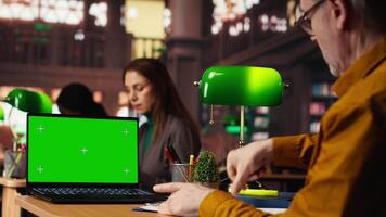 focalizzata anziano uomo lettura accademico testo con croma chiave su pc a il Università, seduta nel Vintage ▾ studia la zona e navigazione in linea corsi. conoscenza e ambizione. telecamera b. video