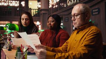 multi-etnisch team van acteurs repeteren hun lijnen in de theater bibliotheek, tonen inzet voor rol voorbereiding en dramaturgie. artiesten beoefenen dialoog met script. camera a. video