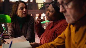 verschillend acteurs repeteren dialoog en karakter uitdrukking in een stil bibliotheek, aan het studeren klassiek drama Speel lijnen met discipline en inzet. theater prestatie oefening. camera a. video