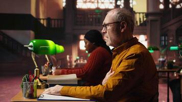 senior vuxen i hyperventilation kris känsla sjuk i de campus bibliotek, har svårighet andas och som visar sårbarhet. gammal studerande har en panik ge sig på nödsituation. kamera a. video