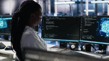 gegevens centrum systeem beheerder werken Aan neurale netwerk software ontwikkeling. Afrikaanse Amerikaans vrouw in server kamer implementeren machine aan het leren technologie gebruik makend van pc, camera een video
