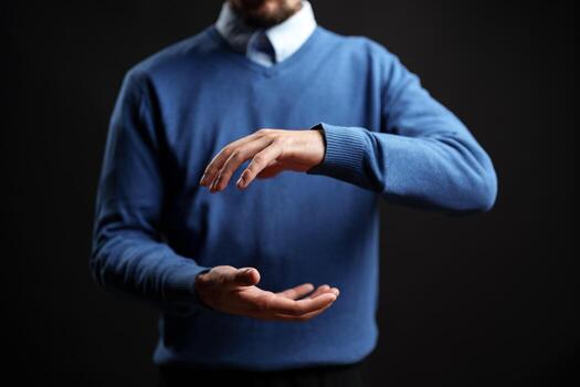 Man performing a hand gesture in a studio setting with dramatic lighting during a creative session photo