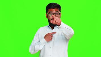 Indian man points directly at camera with confident smile, expressing personal choice, saying its your turn. Arabian guy isolated on green chroma key background showing decision and selection gesture video