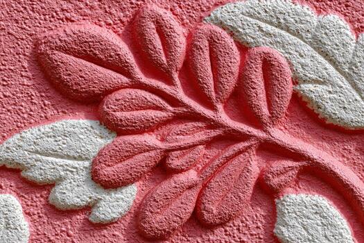 A close up of a pink wall with a leaf design photo
