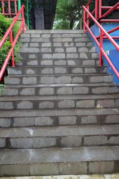 Wet Stone Staircase with Red Railings photo