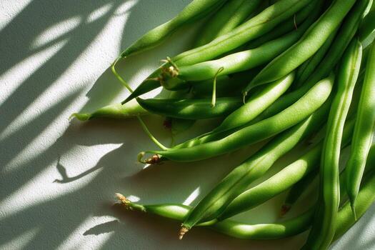 A bunch of green beans on a white surface photo