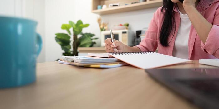 Work from Home Focused professional analyzing data with calculator and notebook photo