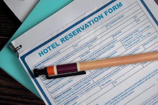 Concept of hotel reservation form write on document isolated on Wooden Table. photo