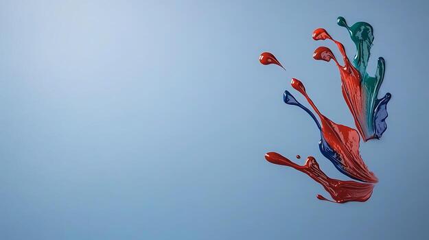 Colorful paint splashes on a smooth blue background, creating an artistic and dynamic effect photo