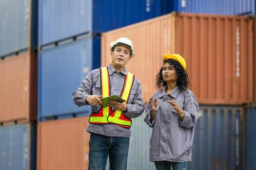 Team of Engineer and foreman worker in hardhat and safety vest checking containers box from cargo, Teamwork concepts photo