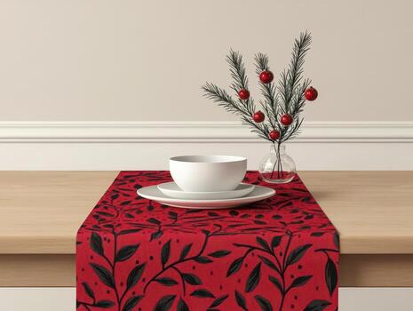 Festive table setting with red leaf-patterned runner and white bowl. photo