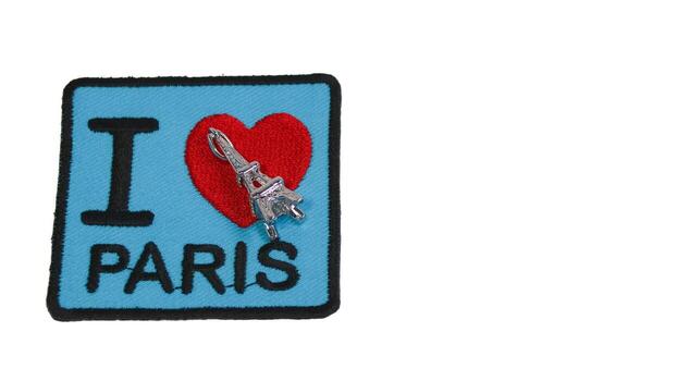 Horizontal image with embroidered fabric I LOVE PARIS patch, red heart, and small Eiffel Tower figure. Designed with eco concept, perfect for travel and destination themes. Text space included. photo