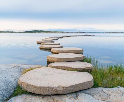 Smooth elliptical stones forming natural steps leading across calm water with distant islands under soft sky photo