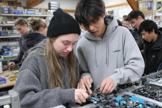 Two young people working on electronics in a workshop photo