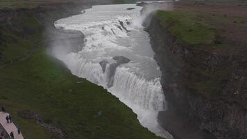 aereo Visualizza di gullfoss cascata nel Islanda, con dinamico acqua fluire, nebbia in aumento, verde pianura, lontano montagne, e un' visualizzazione piattaforma. video