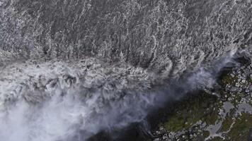 dynamisk antenn se av dettifoss vattenfall i Island, med kraftfull vatten flöde, dimma stigande, och oländig terräng av stenar och mossa omgivande de faller. video