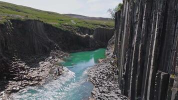 borchia canyon Caratteristiche basalto colonne, un' turchese fiume, e visitatori a piedi lungo percorsi e esplorando vicino il dell'acqua bordo. video