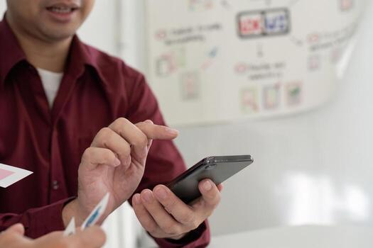 UX and UI Design Collaboration. Team discussing mobile app interface on smartphone. photo