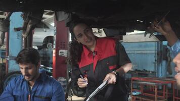 Professional multiracial workers teams, engineers and mechanics cooperate to fix and maintain car suspensions together in garage station, and service jobs in automotive transport industry. video