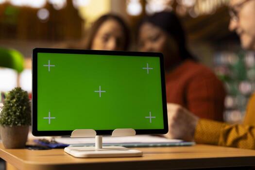 Mature students team focused on writing and studying next to mockup, college library space where people can access academic database for materials. Lifestyle of continuous learning. photo