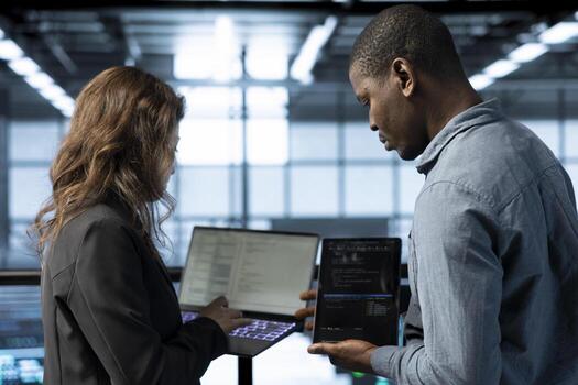 Software developers in data center automating routine maintenance tasks with laptop, executing diagnostic scripts. Server hub IT professionals coding on notebook, adjusting power settings photo