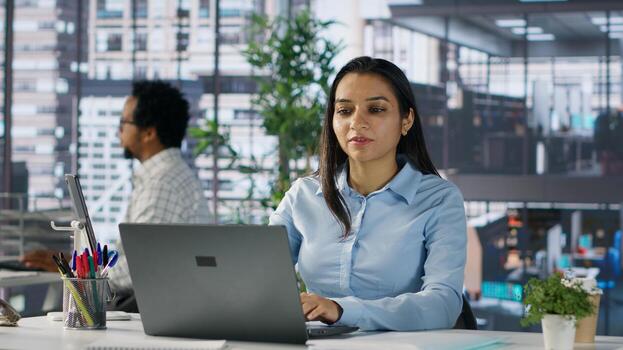 Successful indian entrepreneur working on financial forecasts at his desk, using data and technology to manage business tasks and project development. Company progresses toward its goals. Camera A. photo