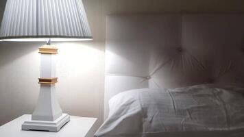 un blanco cama con un lámpara en parte superior video