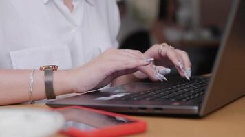 A team collaborates in a cafe, focused on their laptops while discussing important business strategies and planning their next steps in a vibrant and casual setting. video