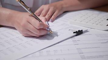 Focusing on strategic business planning, a person writes notes and analyzes data while surrounded by essential documents and spreadsheets in a professional workspace. video