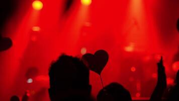Audience immersed in live music performance, surrounded by dynamic red lighting, creating an electrifying ambiance video