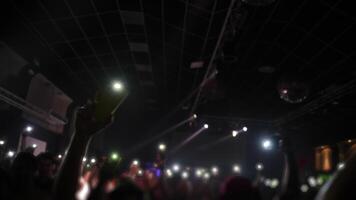 publik på en leva musik händelse, med händer Uppfostrad och smartphones upplyst, skapande ett energisk atmosfär fylld med spänning video