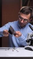 vertical Scientist shaking empty wallet at desk with microscope and books video