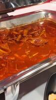 un buffet bandeja lleno con coreano tokpokki en picante rojo salsa. brillante Encendiendo Destacar el vibrante colores y texturas video