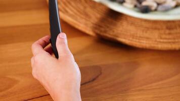 händer byta ut en batteri i en avlägsen kontrollera på en trä- tabell med mjuk belysning video