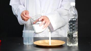 un' scienziato dimostra un' chimico reazione utilizzando cottura al forno bibita e aceto per spegnere un' candela fiamma nel un' laboratorio ambientazione video