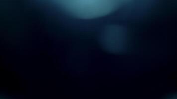 ljus läcka, blå lins blossa från topp av ram, med bokeh blossa på svart bakgrund för täcka över effekt. video
