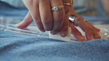 Close-up of view of piece of chalk employed by dressmaker to trace line on denim garments, which tailor can then use as reference for their work. Slow motion. video