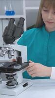 laboratorium forskare kvinna arbetssätt med mikroskop i klinisk miljö ledande biologisk analys som visar modern forskning arbetsflöde och sjukvård innovation med fokus på medicinsk diagnostik video