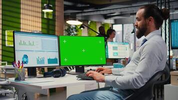 Business manager working on report writing next to chroma key screen, reviewing data analytics in the office. Specialist building a business strategy with vision, planning progress. Camera A. video