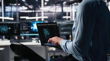 cerca arriba de desarrollador en datos centrar codificación con asistencia en ordenador portátil. eso experto apalancamiento artificial inteligencia grande idioma modelo en cuaderno a resolver tareas, cámara un video